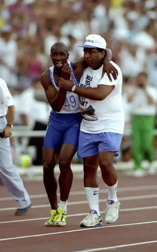 Derek Redmond, supported by his father, limping to finish his race at the 1992 Barcelona Olympics.