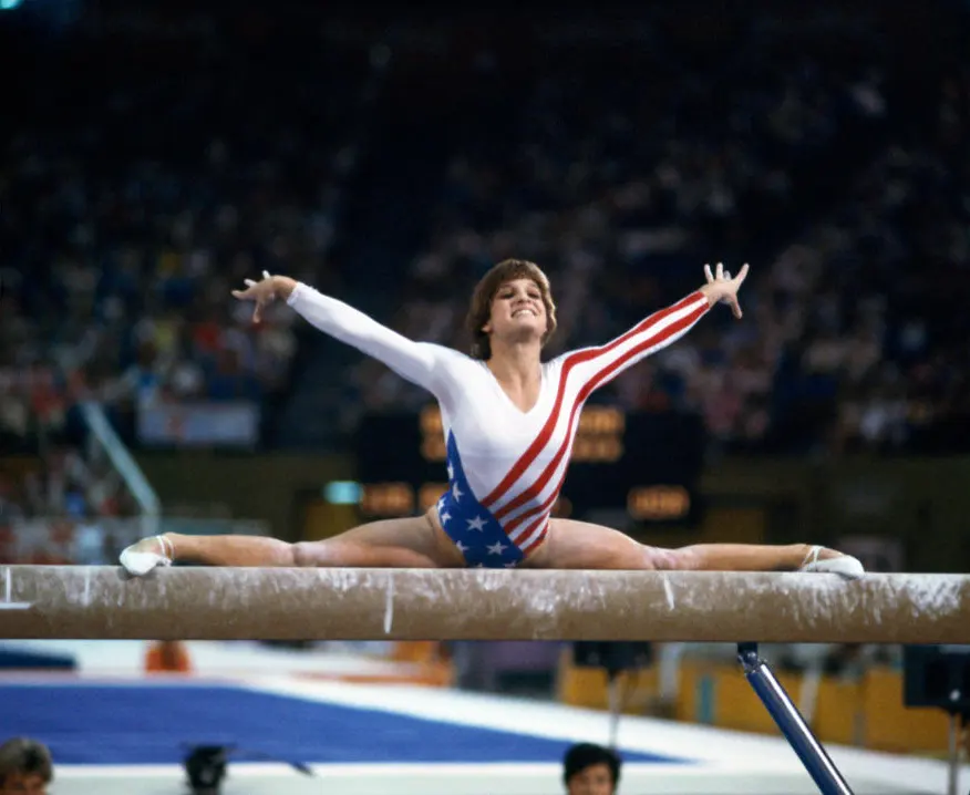 Mary Lou Retton smiling widely after sticking a perfect landing