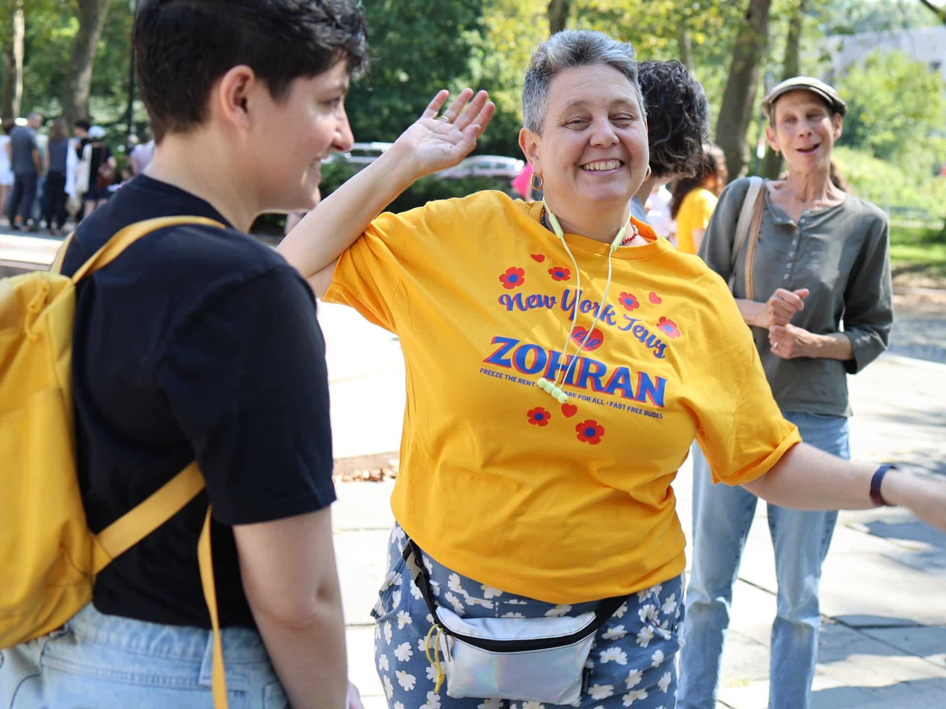 Woman wearing a T-shirt that reads “New York Jews Vote for Zohran” at a Mamdani campaign event, showing community-based support.