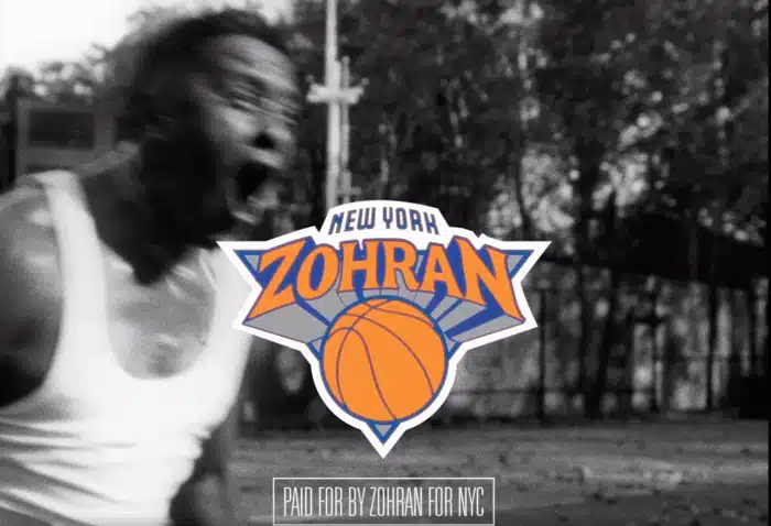Modified “New York Zohran” logo mimicking the New York Knicks’ blue‑and‑orange emblem, superimposed over a black‑and‑white background of a shouting man playing basketball.